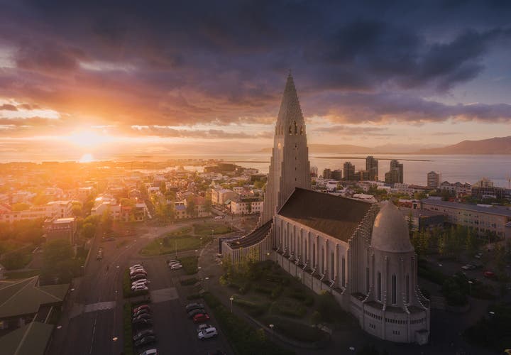 Hallgrímskirkja Church in Reykjavík at sunset, silhouetted against a colorful evening sky.