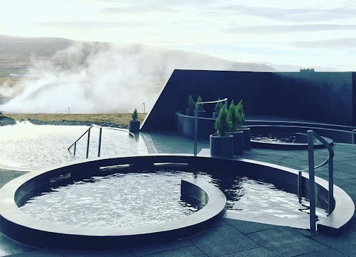 Steam rises from the modern hot tubs at Krauma Geothermal Baths in West Iceland, near Deildartunguhver hot spring.
