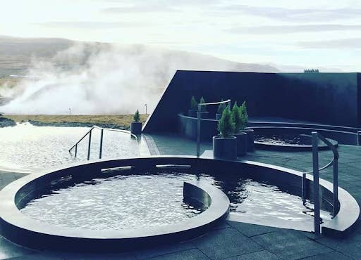 Steam rises from the modern hot tubs at Krauma Geothermal Baths in West Iceland, near Deildartunguhver hot spring.
