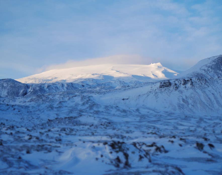 冬の柔らかな光に包まれた雪のスナイフェルスヨークトル氷河と火山。自然愛好家に人気の絶景スポット。