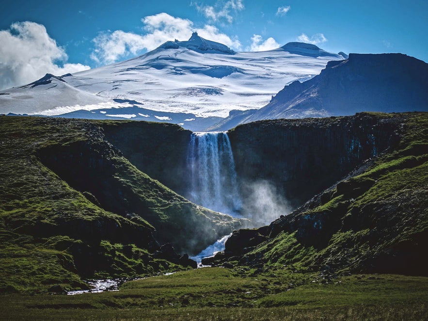 Svöðufoss waterfall with Snæfellsjökull glacier in the background, on Iceland’s scenic Snæfellsnes Peninsula.