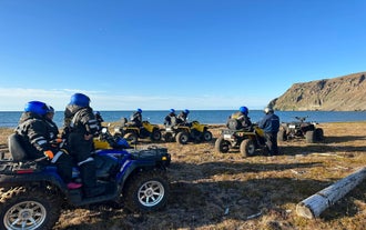 Travelers riding ATVs while enjoying the scenic coastal view in Northeast Iceland.