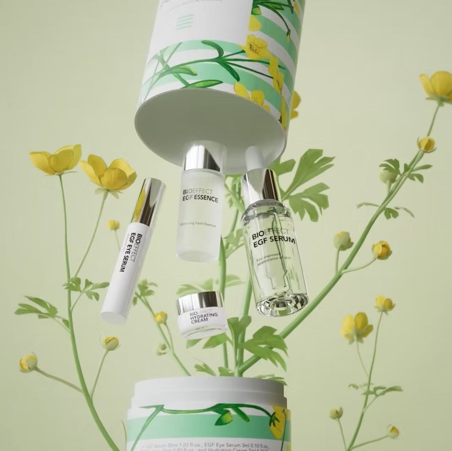 BIOEFFECT EGF skincare products, including serum, essence, eye serum, and cream, float among yellow flowers.