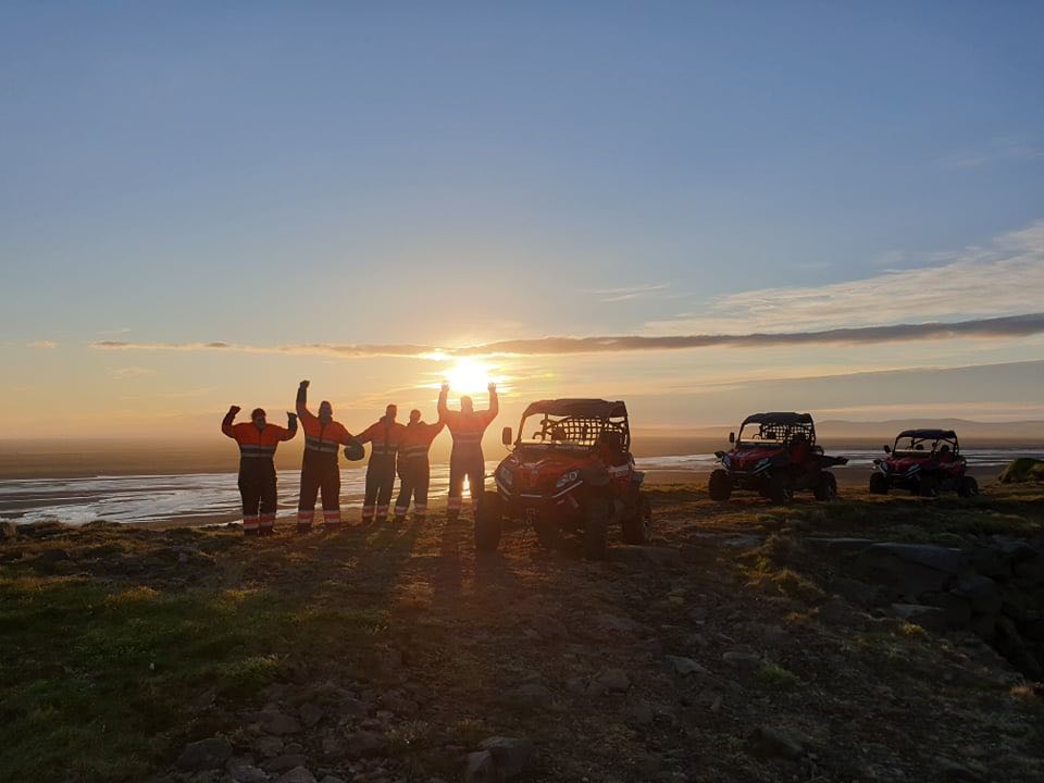Een groep mensen op een buggytour bij zonsondergang in IJsland.