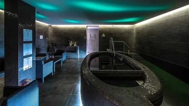 The spa room in Silfra at Hotel Island has a unique lighting that resembles the northern lights, a hot tub, and a pool.