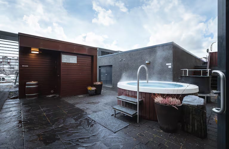 Outdoor hot tub and sauna at Hilton Reykjavik Nordica Spa, offering relaxation under an open sky.