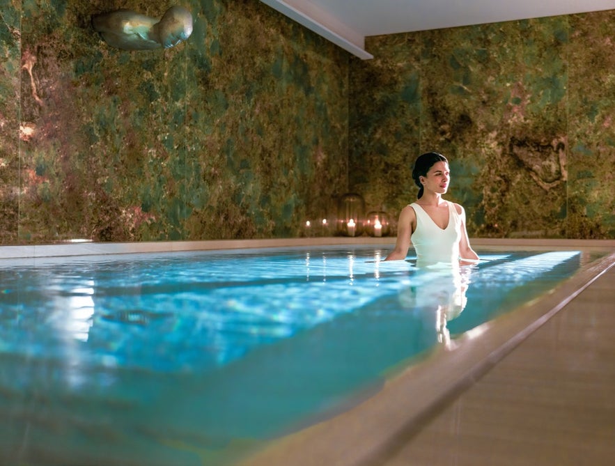 A woman relaxes in the serene pool of Parliament Spa at the Iceland Parliament Hotel.