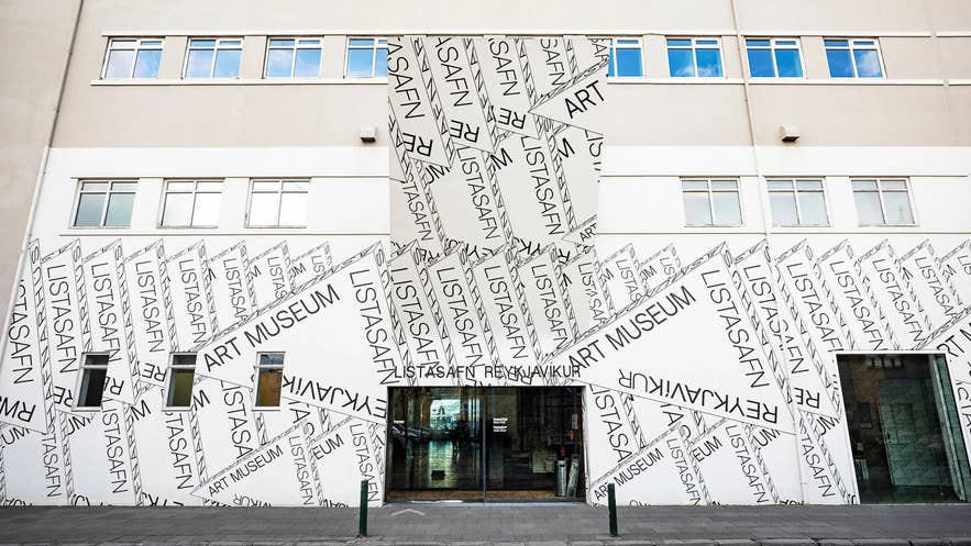 Entrance of the Reykjavik Art Museum Hafnarhús, featuring bold graphic text design spelling "Listasafn" and "Art Museum" across the white façade.