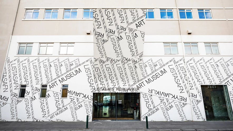 Entrance of the Reykjavik Art Museum Hafnarhús, featuring bold graphic text design spelling "Listasafn" and "Art Museum" across the white façade.