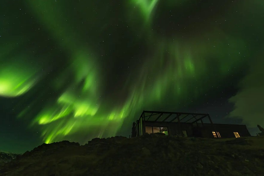 Observa la aurora boreal en las Aguas Termales de Hvammsvik durante el invierno.