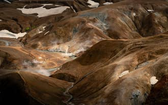 Hikers walking along Kerlingarfjoll hiking trails in steaming geothermal valleys.
