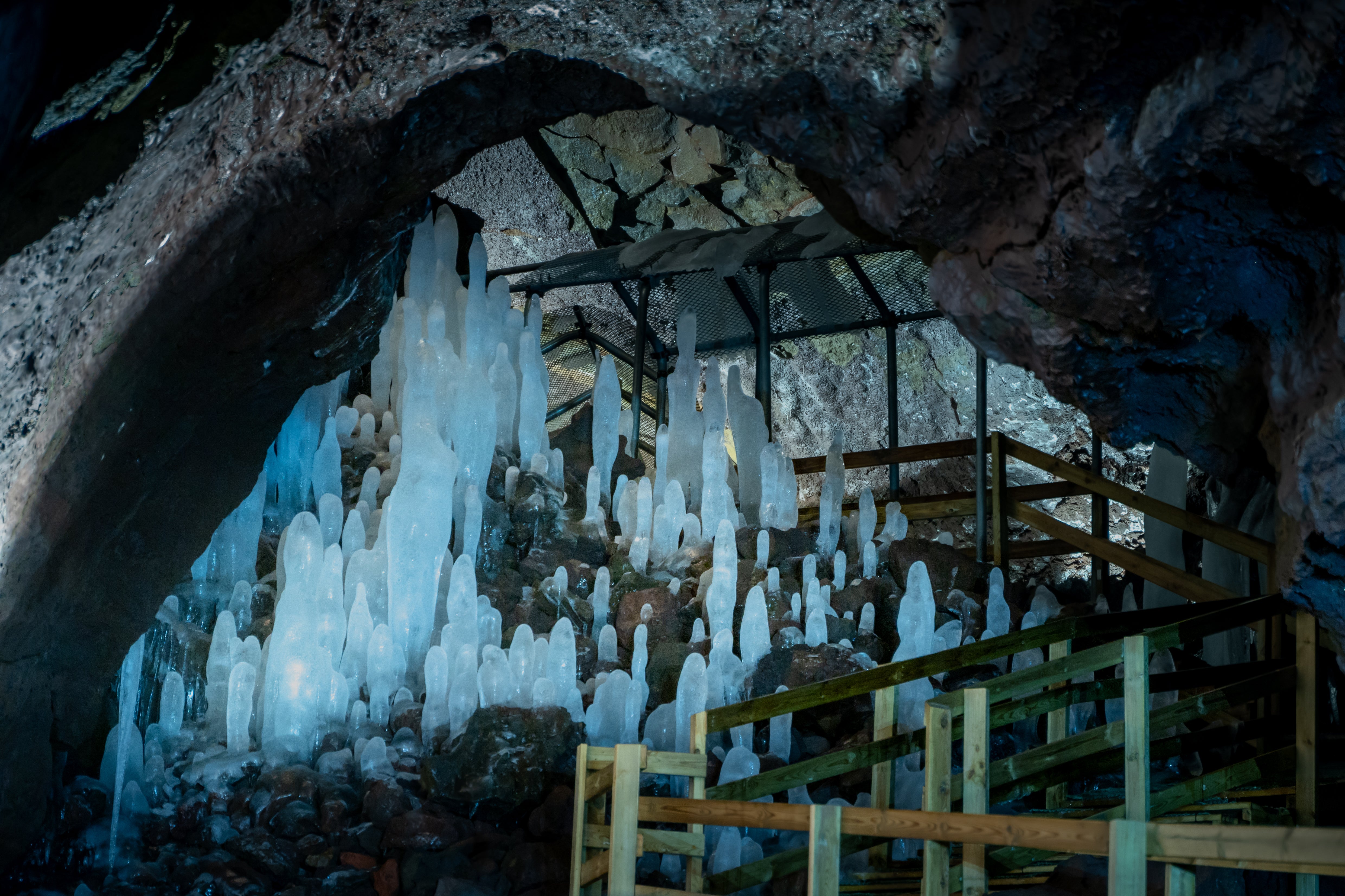 Ice formations rise from the ground inside Vidgelmir Lava Tunnel in West Iceland.