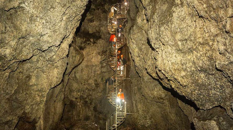 Tour group descends a spiral staircase deep inside Vatnshellir Cave’s volcanic chamber.
