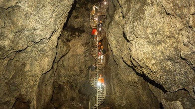 Tour group descends a spiral staircase deep inside Vatnshellir Cave’s volcanic chamber.