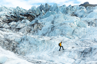 Jagged glacier ice forms sharp peaks and deep crevasses, shaped by years of movement and melting.