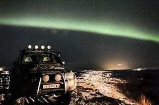 En superjeep under nordlyset om natten i Island.