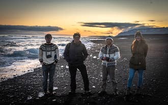 A group of travelers pose on Diamond Beach on Iceland's South Coast, known for the chunks of ice that shimmer like diamonds.