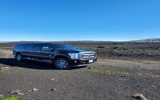 Black super jeep parked on volcanic terrain in South Iceland.