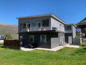 Seydisfjordur Apartment from the outside, a two-story building with a balcony on the first floor.