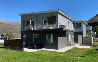 Seydisfjordur Apartment from the outside, a two-story building with a balcony on the first floor.