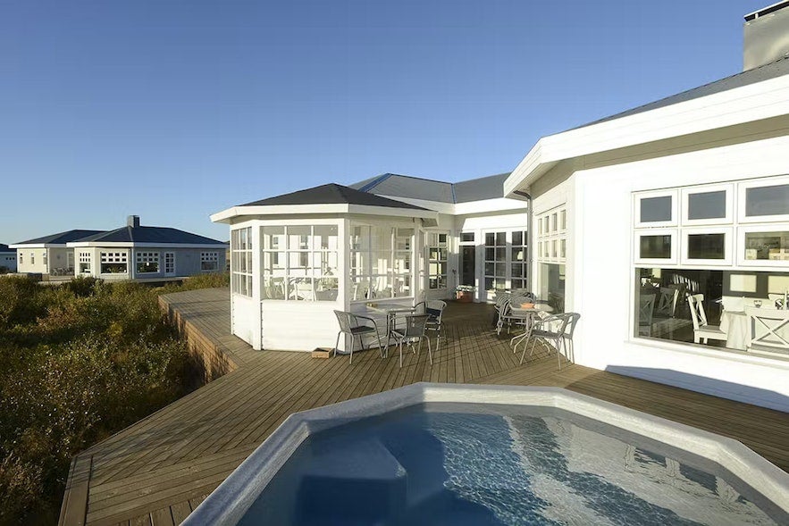 An external view of an apartment and hot tub at Hotel Grimsborgir in Iceland.