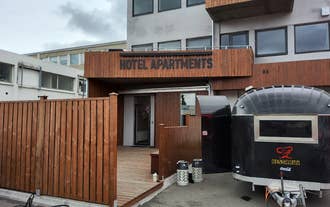 Exterior of Tryggvabraut 24 with wood paneling and entrance marked Hotel Apartments.