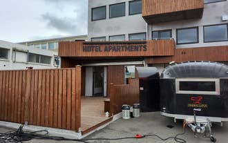 Exterior of Tryggvabraut 24 with wood paneling and entrance marked Hotel Apartments.