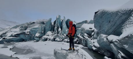 A hiker gazes at the unique ice formations while hiking on the Solheimajokull glacier in Iceland.