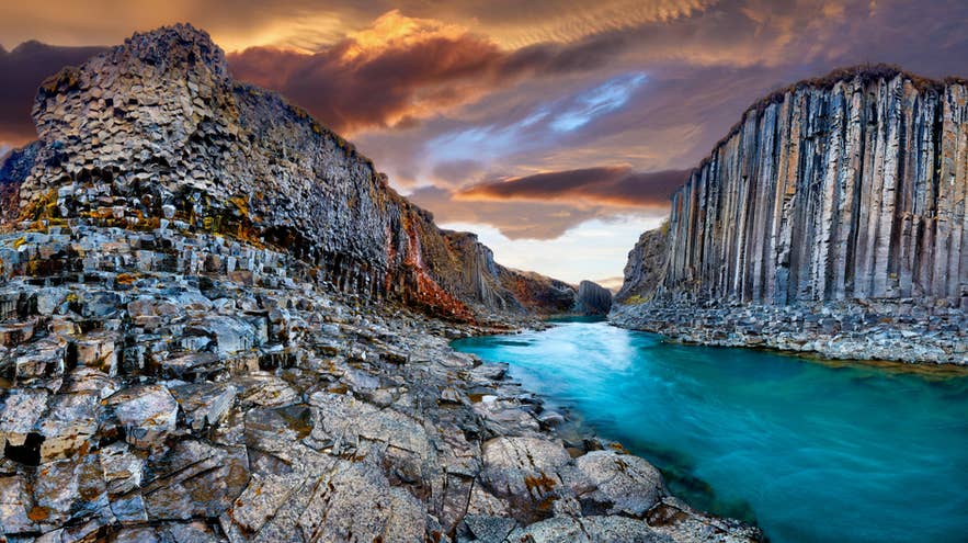 De Stuðlagil-kloof bij zonsondergang met opvallende basaltzuilen en een turquoise rivier, een van de mooiste natuurlandschappen van IJsland.