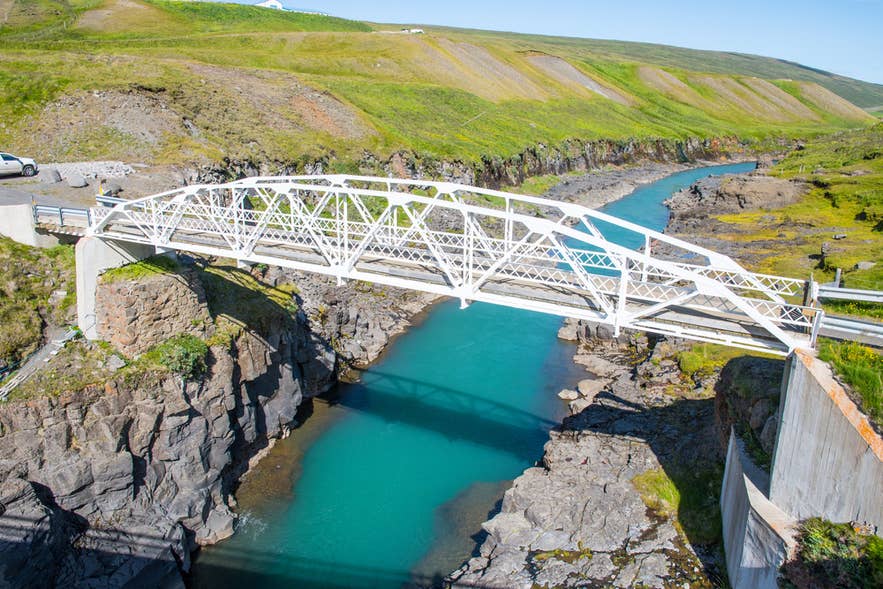 A view of the old white steel bridge in Jokuldalur Valley, marking the start of the hiking route to Studlagil Canyon in East Iceland.