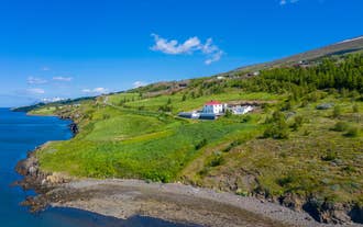 北アイスランドのエイヤフィヨルズルを見下ろす緑の丘に建つHalllandsnes Apartmentsの外観写真