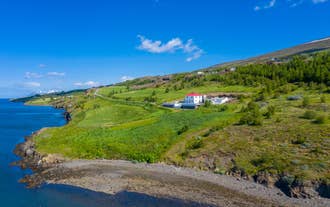 Halllandsnes Apartments på en grön sluttning med utsikt över Eyjafjordur på norra Island.