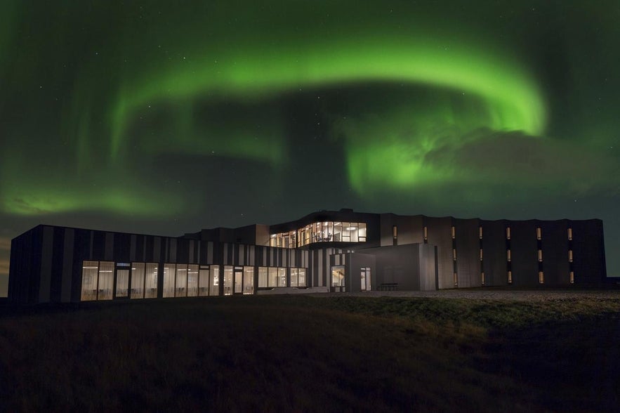 Landhotel sormontato dall'aurora boreale.