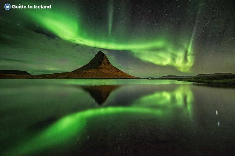The northern lights reflect perfectly in the seas under Mount Kirkjufell.