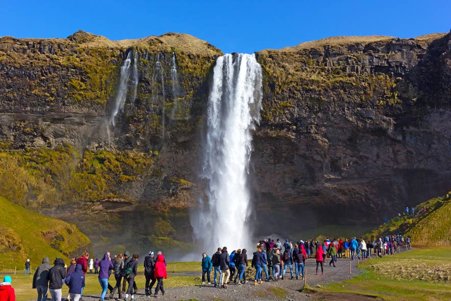 Multitud en la cascada Seljalandsfoss, una atracción natural muy popular en Islandia en julio.