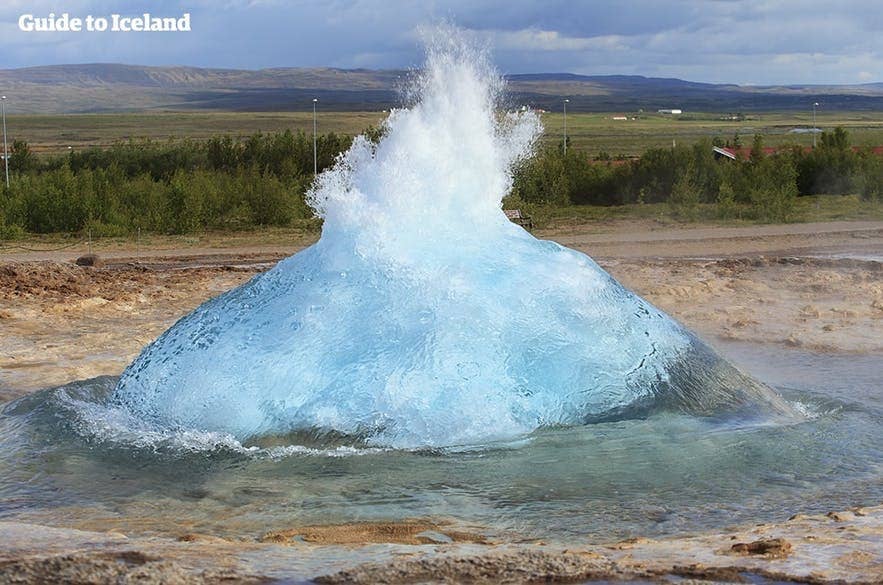 Strokkur prepares to erupt on the Golden Circle in Iceland on a clear summer day.