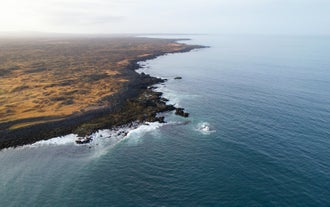 Aerial view of rugged volcanic shoreline along the Ottarsstadir coast.