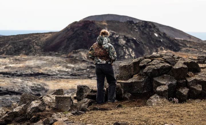 Matkailija ihailee uutta tulivuoren kraatteria Reykjanesissa.