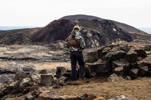 A visitor in Iceland admiring a new volcanic crater in Reykjanes.
