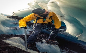 Un hombre bebe de un arroyo glaciar fresco mientras practica senderismo en el glaciar Vatnajokull.