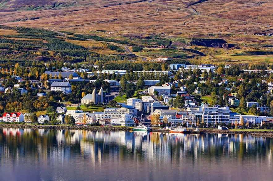 Akureyri townscape reflected in the water near Dettifoss Waterfall in North Iceland during autumn.