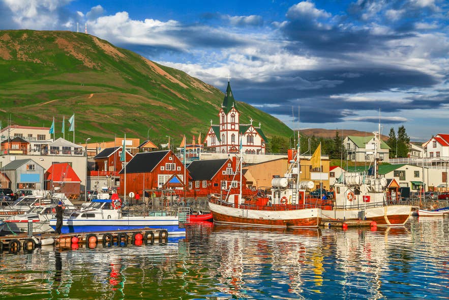 Kleurrijke haven en kerk in Husavik, een populaire walvisspotplaats vlak bij de Dettifoss-waterval in Noord-IJsland.