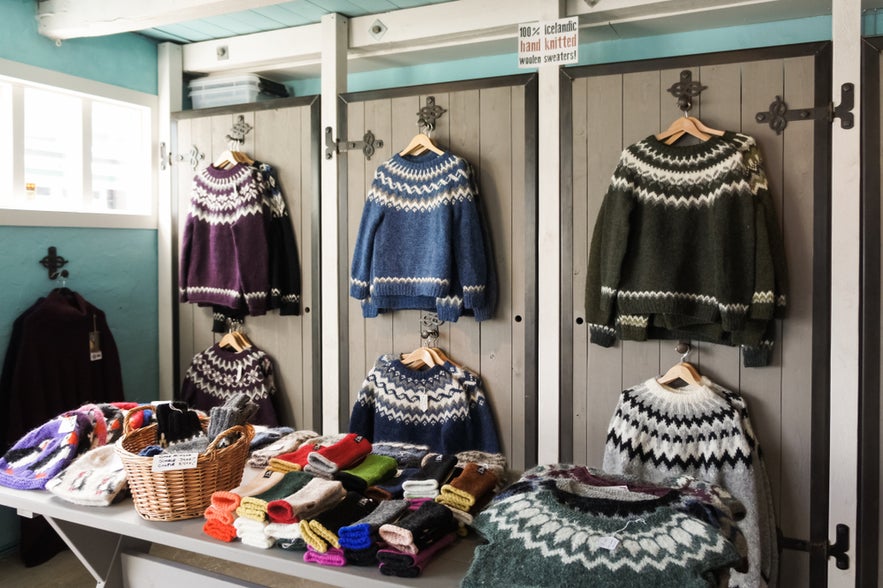 Display of Icelandic wool sweaters, hats, and gloves in a cozy shop, showcasing traditional hand-knitted woolen clothing.