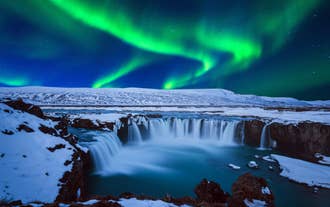 Les superbes aurores boréales illuminent la cascade de Godafoss en hiver en Islande.