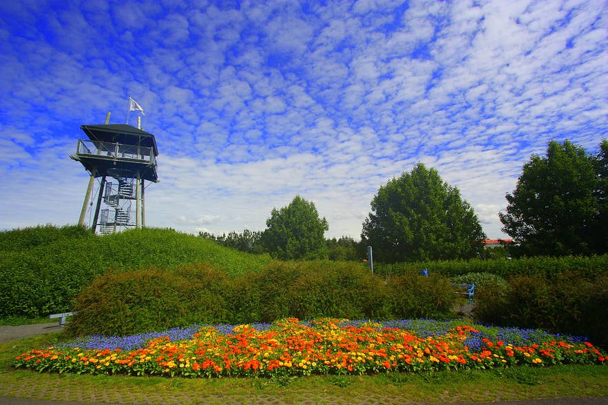 Colorful flowerbed and viewing tower at the free Reykjavik Botanical Gardens in Laugardalur Valley.