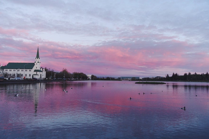 Staw Tjornin. Obserwowanie północnego słońca jest jedną z najlepszych darmowych rzeczy do zrobienia w Reykjaviku.