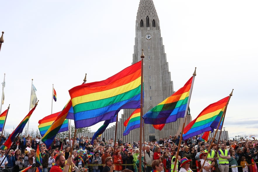 Crowd waving rainbow flags at a Pride event in front of Hallgrimskirkja church in Reykjavik, Iceland. Crowd waving rainbow flags at a Pride event in front of Hallgrimskirkja church in Reykjavik, Iceland.