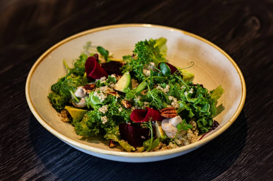 Reykjavik Kitchen供应的新鲜沙拉，搭配绿叶蔬菜和山核桃。这是一家位于雷克雅未克、提供素食和纯素选择的餐厅。