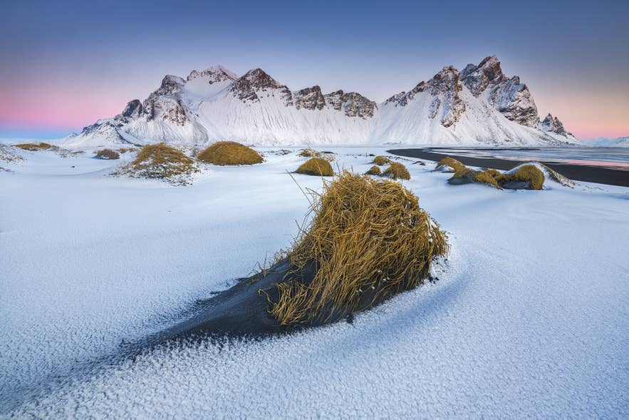 Snow falling on the peaks of Vestrahorn in East Iceland, the kind of scene that inspired Naddodd to call the country Snaeland