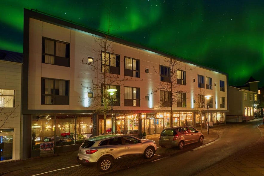 A breathtaking view of the northern lights and Alda Hotel in Reykjavik.